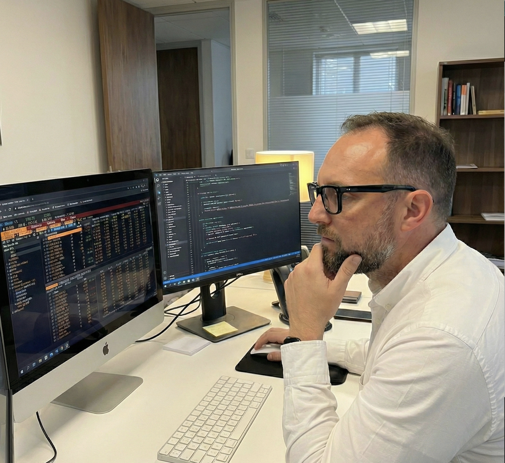 Shane working at dual monitors with code on screen